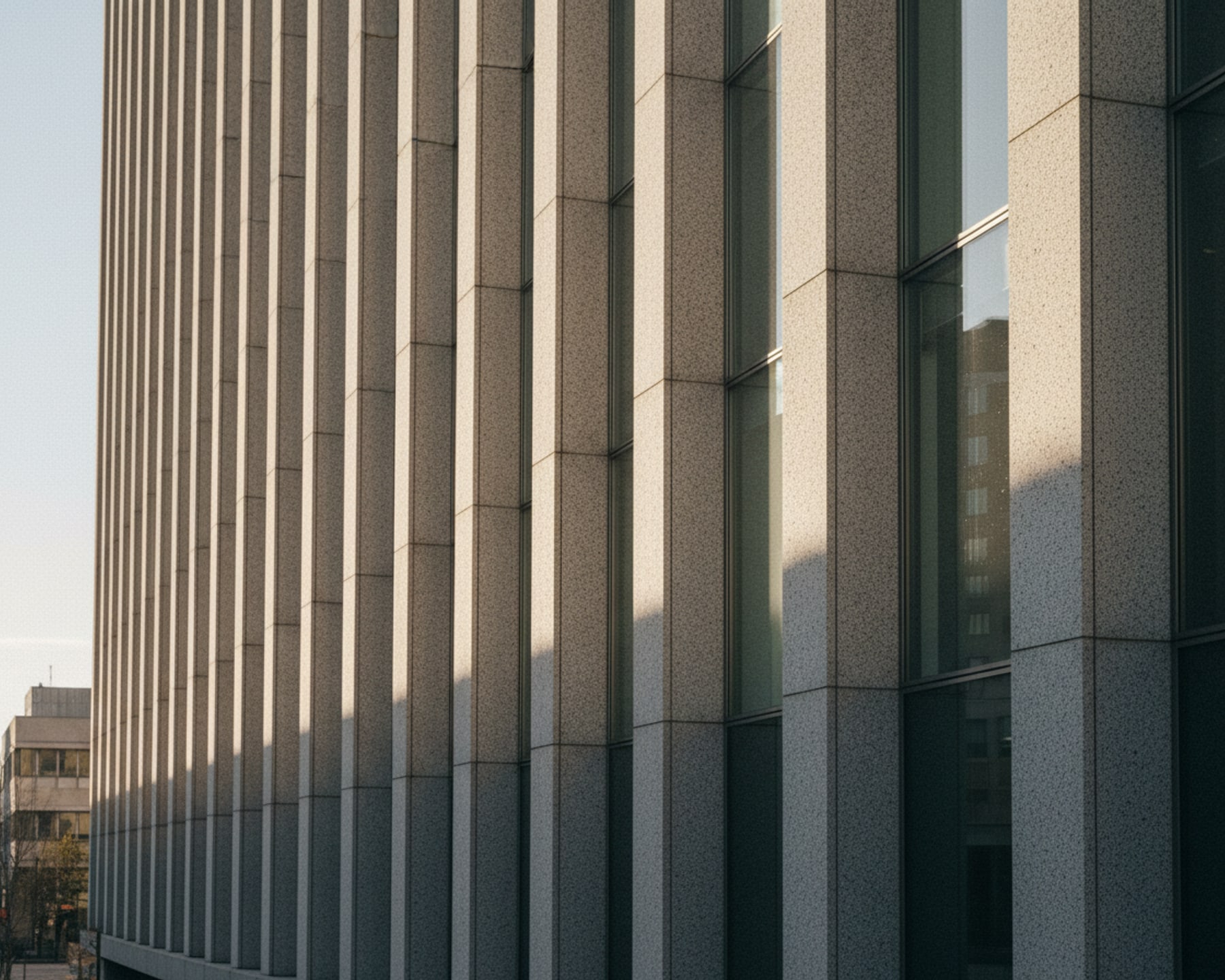 Colonnaded civic building in early morning light, empty forecourt